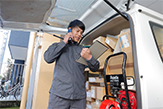 水道修理の道具を車から出す水道修理屋